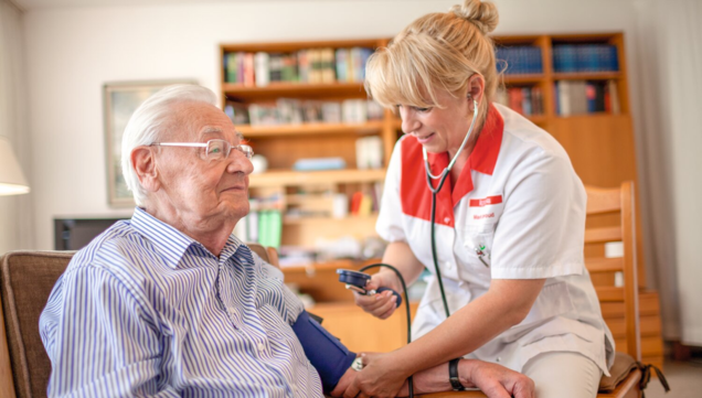 Pflegekraft misst Blutdruck beim Patienten
