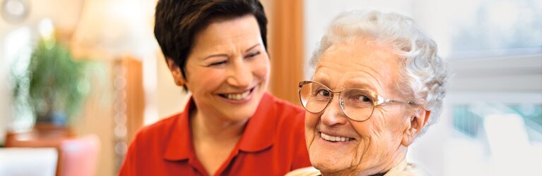 Pflegekraft unterhält sich mit Seniorin