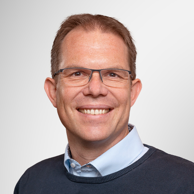 Porträt einer Person in Business-Kleidung vor neutralem Hintergrund