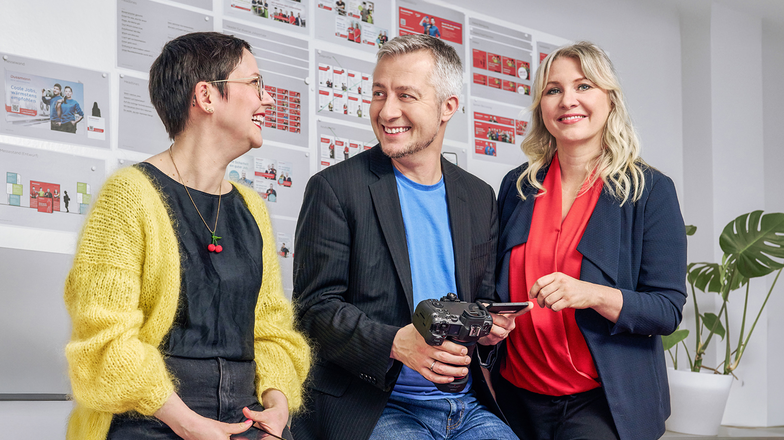 Gruppe vor Wand mit Kommunikations- und Marketingmaterialien