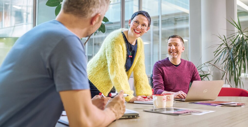 Kreatives Meeting mit Laptop und Marketingmaterialien