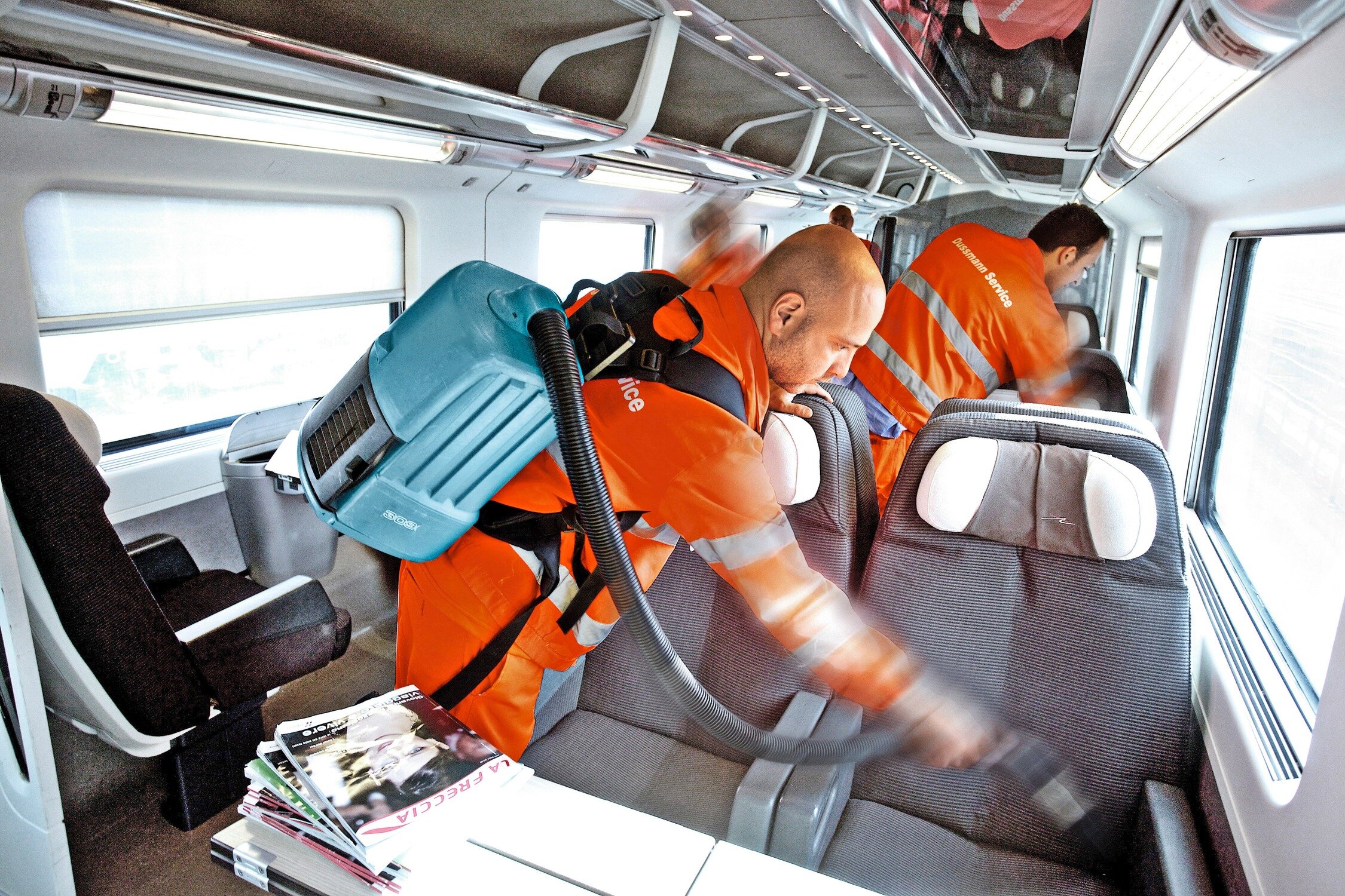 Reinigungspersonal reinigt Sitze in einem Zug