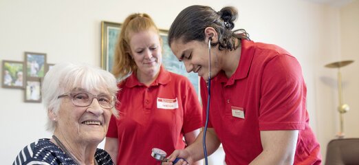 Auszubildende von Kursana misst Blutdruck bei Seniorin 