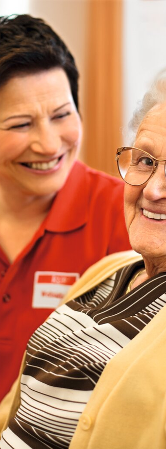Pflegekraft unterhält sich mit Seniorin