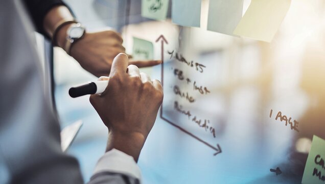 Mann malt Matrix an einem Whiteboard 